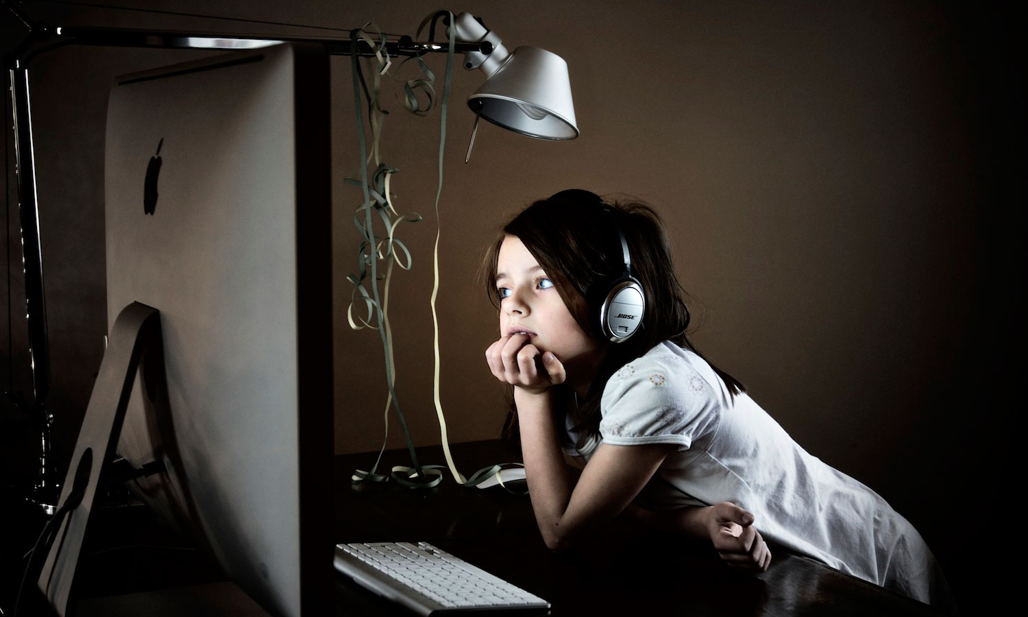 una bambina con le cuffie guarda uno schermo e contempla il mondo del digital